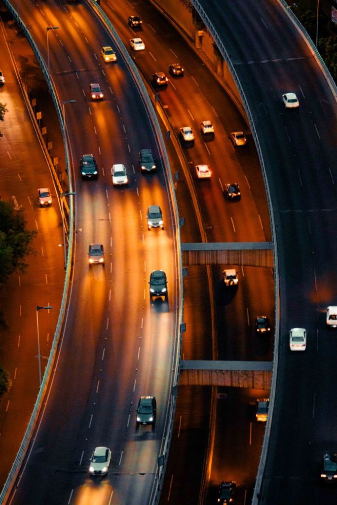 Aerial view of illuminated highway traffic in Mexico City at dusk, showcasing city dynamics and infrastructure.