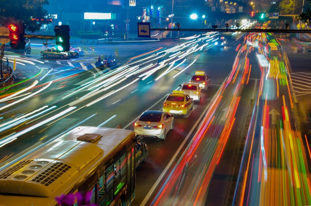 Long exposure of bustling urban traffic in Fuzhou city at night with vibrant light trails.